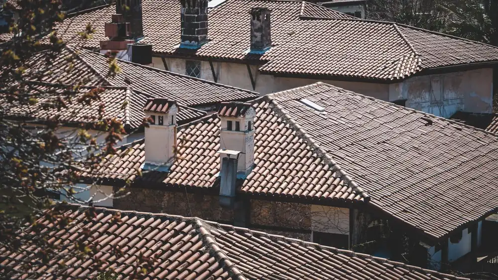 Weathered barrel-tile roofs and stucco chimneys on adjoining homes